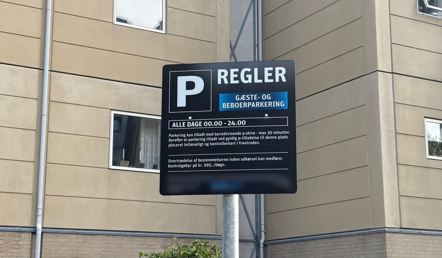 Privat parkeringsskilt på en boligvej med regler for p-skive, tidsrum og kontrolgebyr.