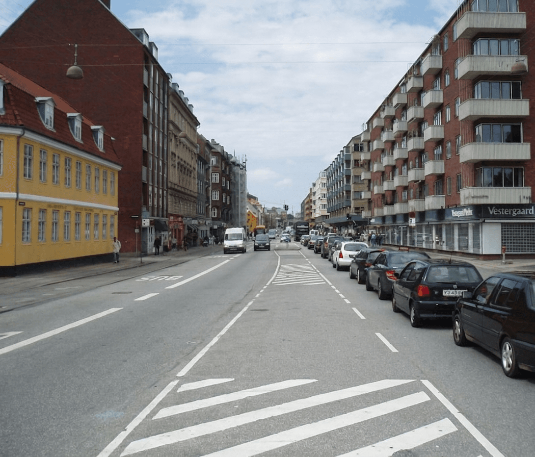 Bygade i København med parkerede biler og afmærkede kørebaner.