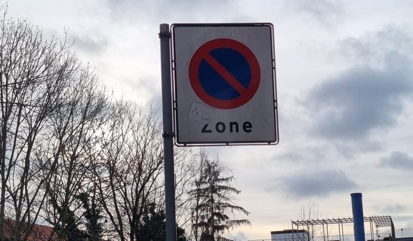 Et dansk parkeringsskilt fotograferet tæt på en vej.