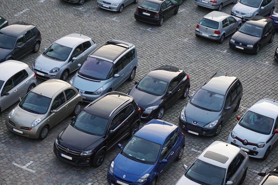 Parkerede biler på en parkeringsplads set oppefra.
